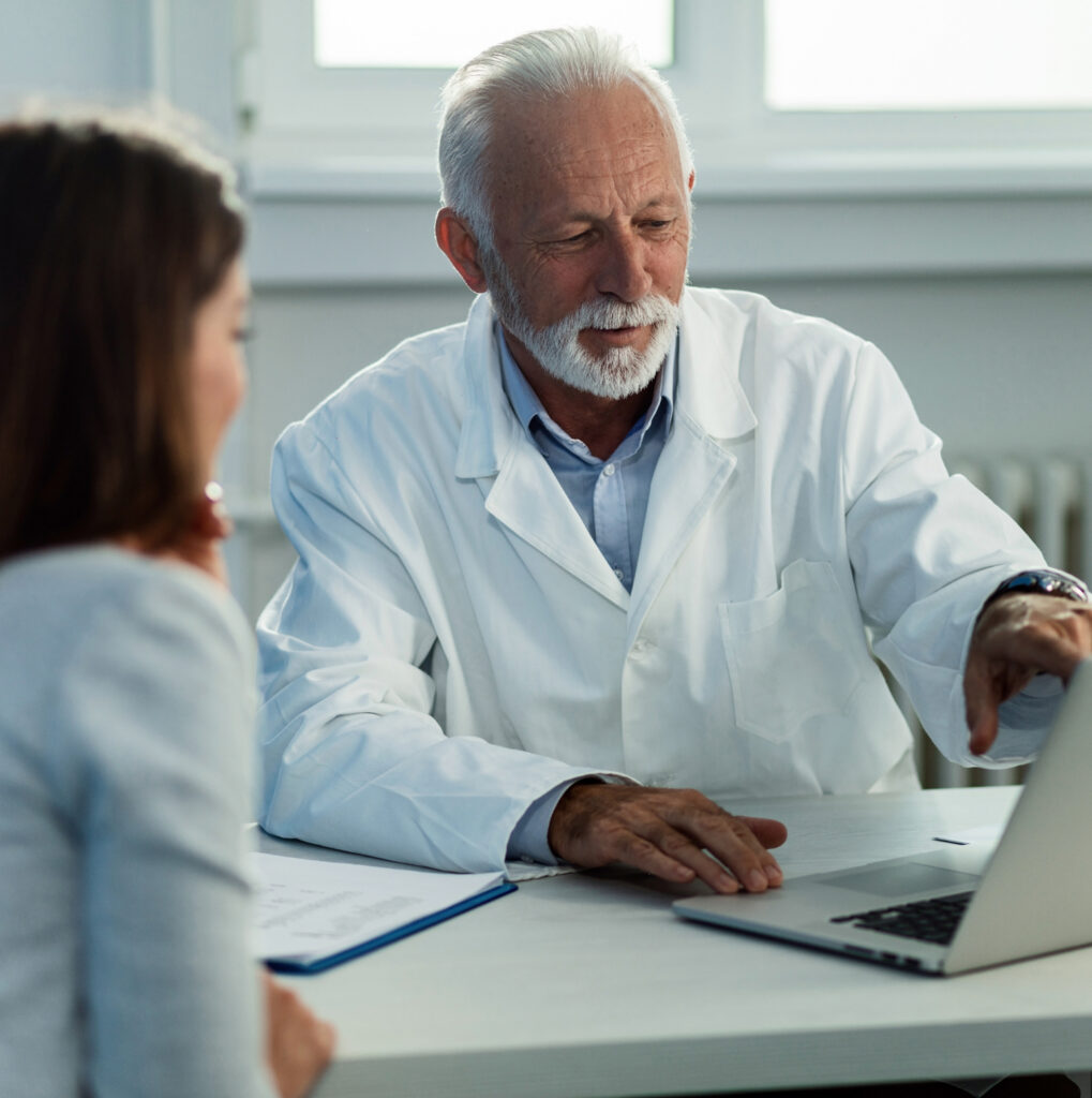 Médecin expliquant des informations sur un ordinateur portable à une patiente